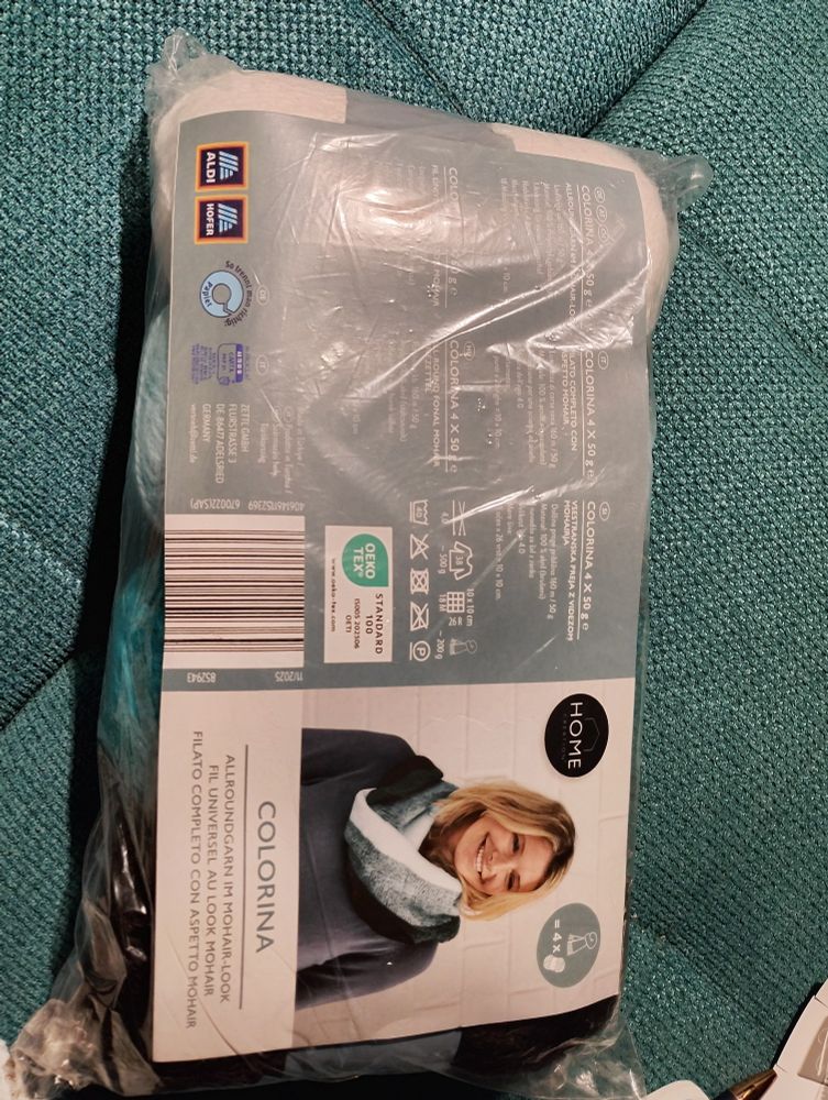 Other side of the garn package showing a woman wearing the loop scarf in those four colors
