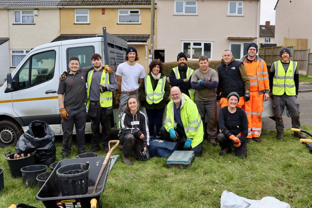 A diverse group of 12 individuals stands proudly in front of a van after collaboratively planting 20 trees in Stockwood, Bristol. This team comprises colleagues from One Tree Per Child, Bristol City Leap, Bristol City Council, and other organisations, showcasing their commitment to community and environmental stewardship.