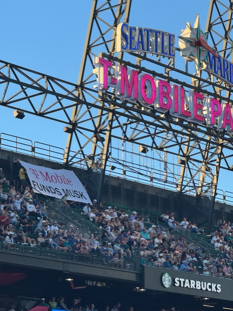 Giant banner under T-Mobile sign in the bleachers that reads "T-Mobile funds Musk"