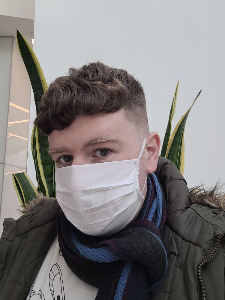 A man in his early thirties wearing a face mask