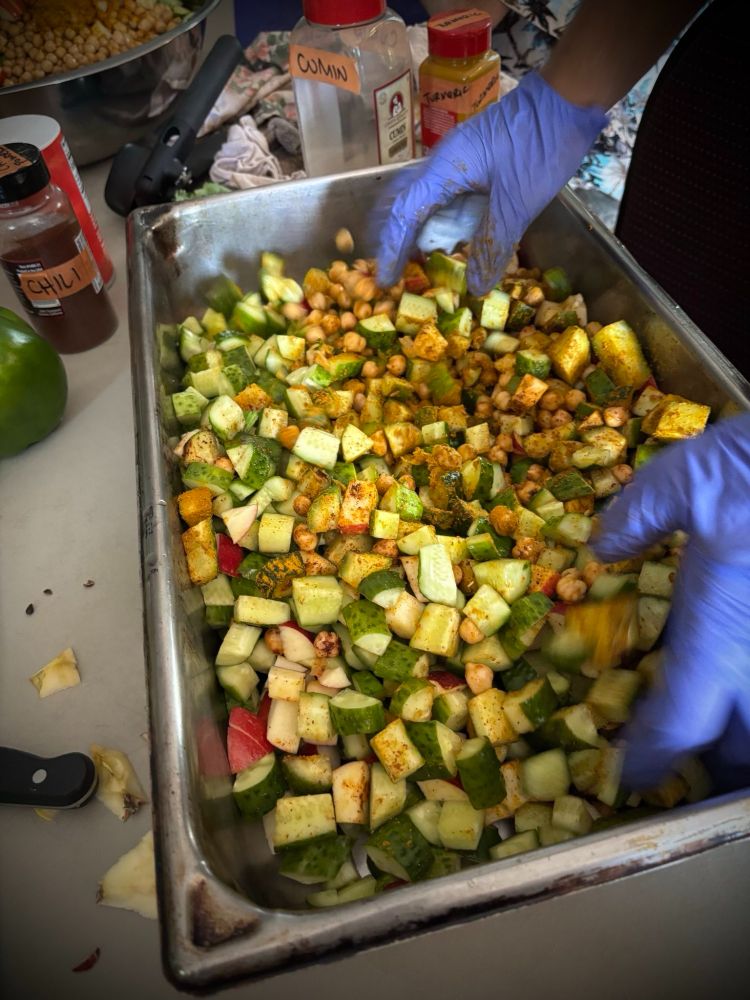 Salad being mixed up. There's squash and garbanzo beans and apples!