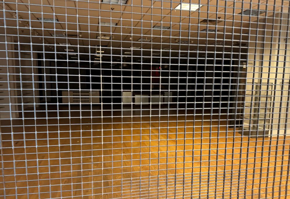 Empty darkened store with the gate pulled down in front of the entrance