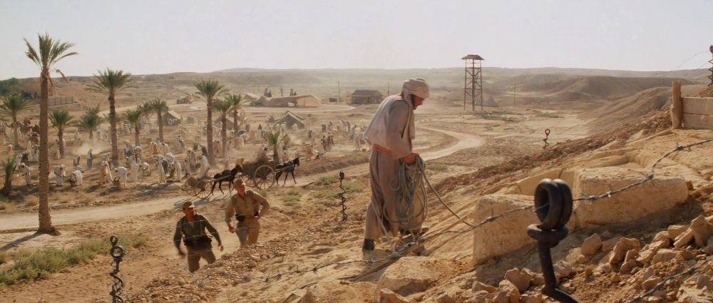 Still from Raiders of the lost Ark: German soldiers approach Sallah as he waits outside as Indy is in the map room.