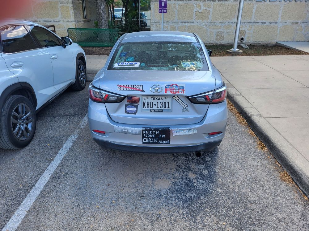 Car with a cultist amount of pro-trump paraphernalia attached to it.  