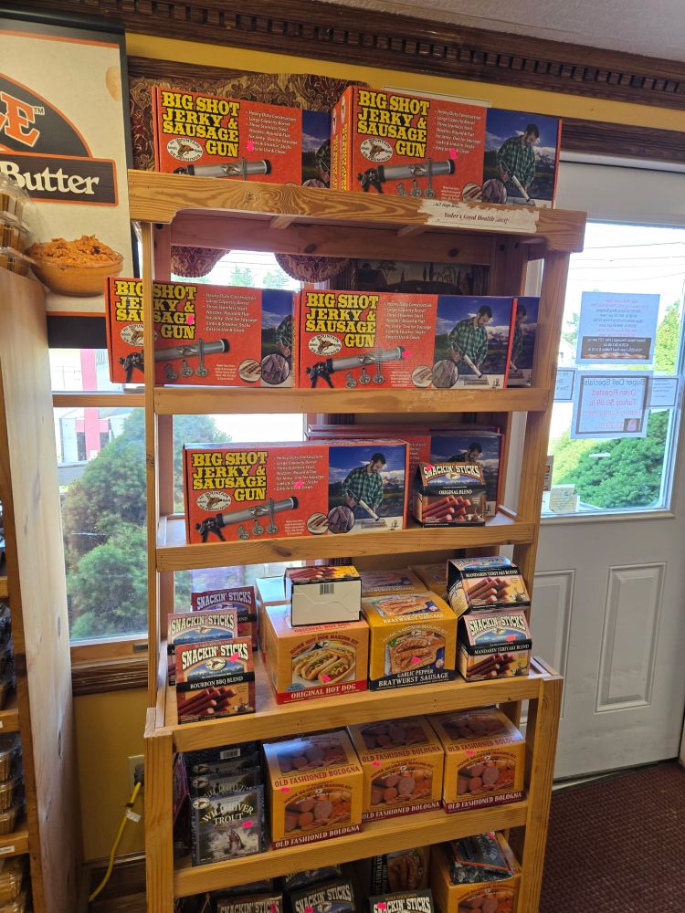 A rack of various smoked meat apparatuses, including the “Big Shot Jerky & Sausage Gun”