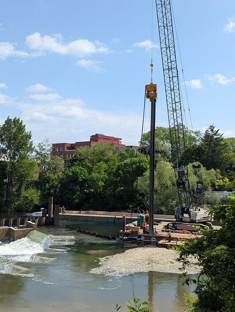 A crane doing the heavy lifting to dismantle the barrier on the south side of the Boardman Ottaway River at the FishPass facility.