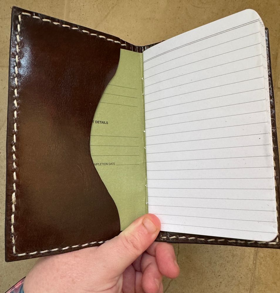 The inside of the note book cover features two dark brown pockets and a field notes type of notebook that has had the cover slipped into the pockets. 