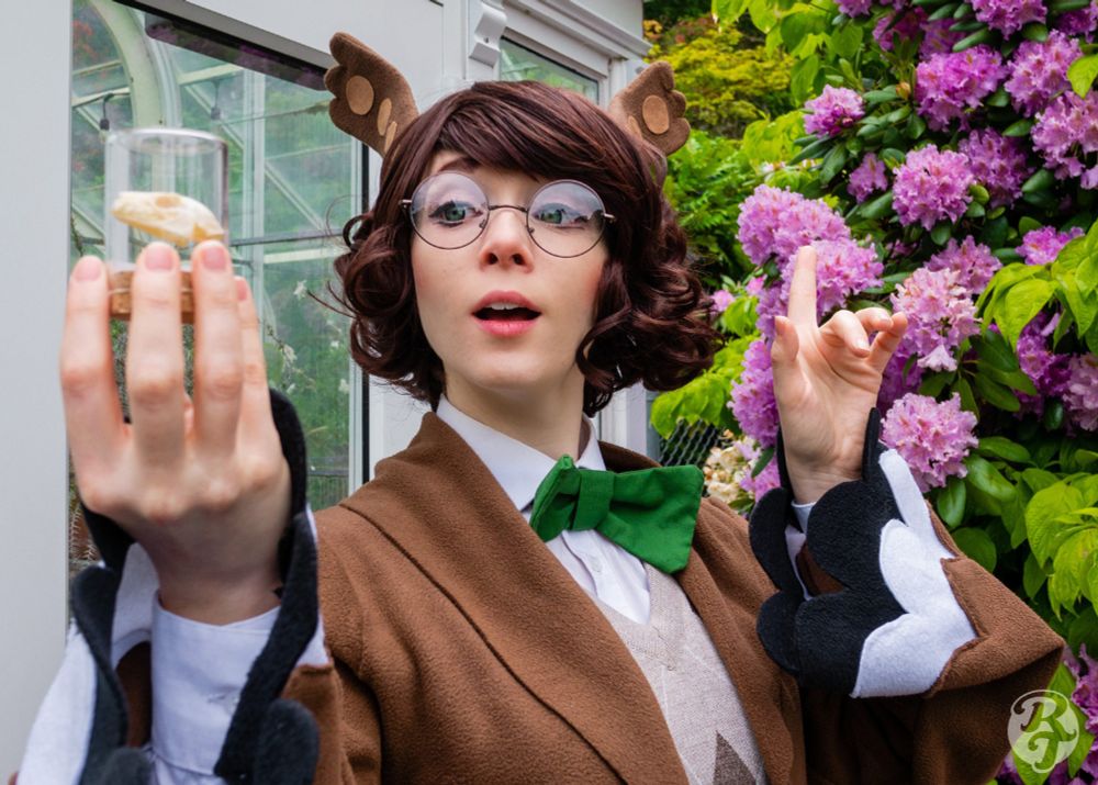 White woman in Blathers (Animal Crossing) Cosplay - looking at a small skull in a jar with a surprised expression.