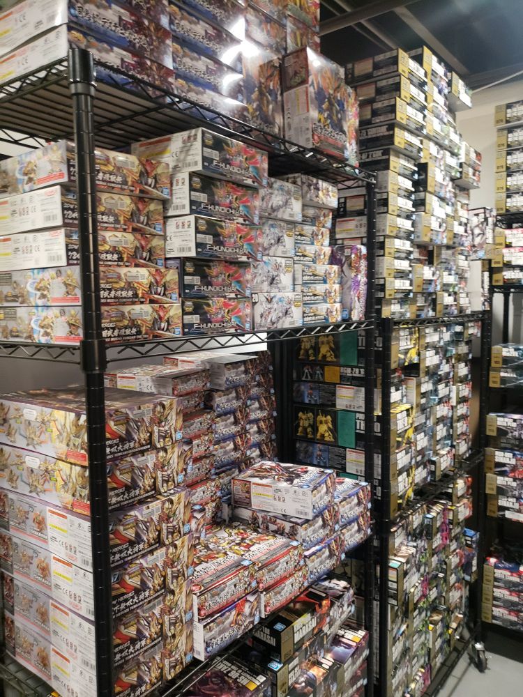 Gunpla boxes on full shelves and from the bottom to the ceiling.