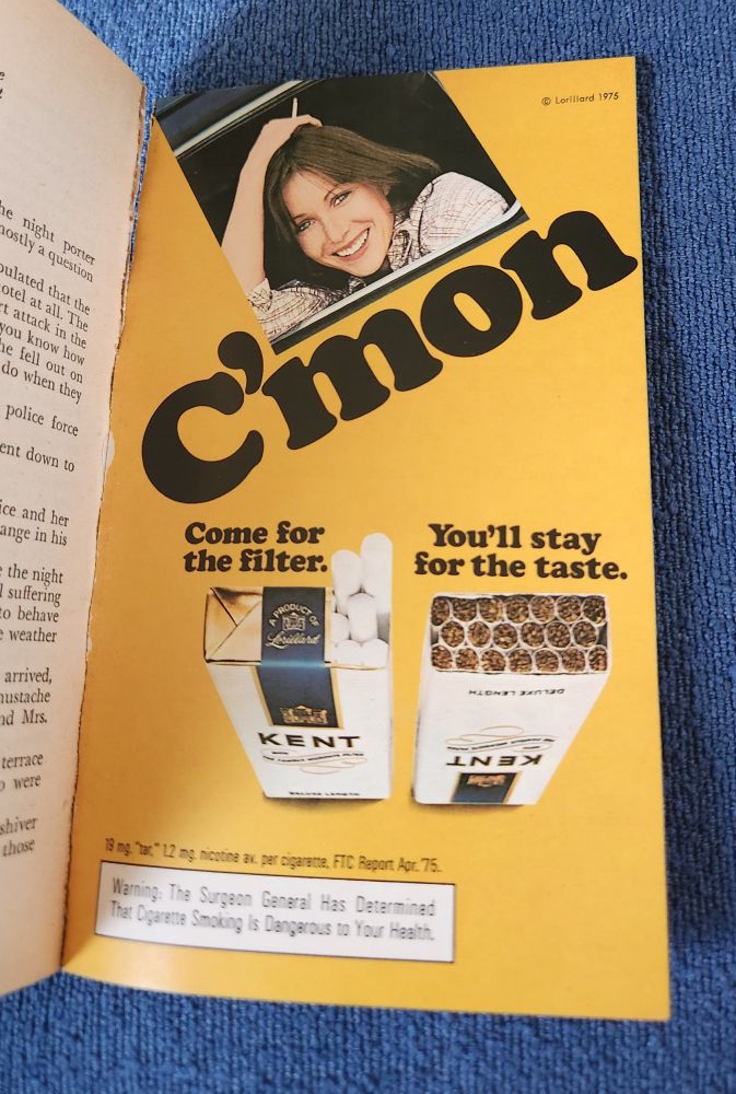 A smoking ad in a book that says
C'mon Come for the filter. You'll stay for the taste.