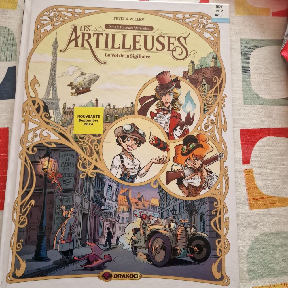 Couverture de la bande dessinée tome 1 sur 3, " Les artilleuses. Le vol de la Silligaire.  Dans le Paris des merveilles. Pevel et Willem. Édition Drakoo"
Paris Steampunk fantasy 1911. 
Fond de la couverture dans des tons chauds, orangés. Haut : un ciel jaune orangé sur lequel on voit des toits de Paris, la Tour Eiffel, et un dirigeable.
Bas de la couverture une rue de Paris, un allumeur de réverbère qui l'allume avec un petit dragon, une voiture ancienne qui démarre avec les protagonistes et un dragonneau qui marche dans la rue.
Au centre de la couverture les trois femmes qui sont les personnages principales de la BD.
La première a une flamme bleue qui sort de la main, la seconde l'ongle avec des explosifs, la troisième porte un Tromblon sur l'épaule. On ne voit que leur buste, elles sont vêtues genre steampunk