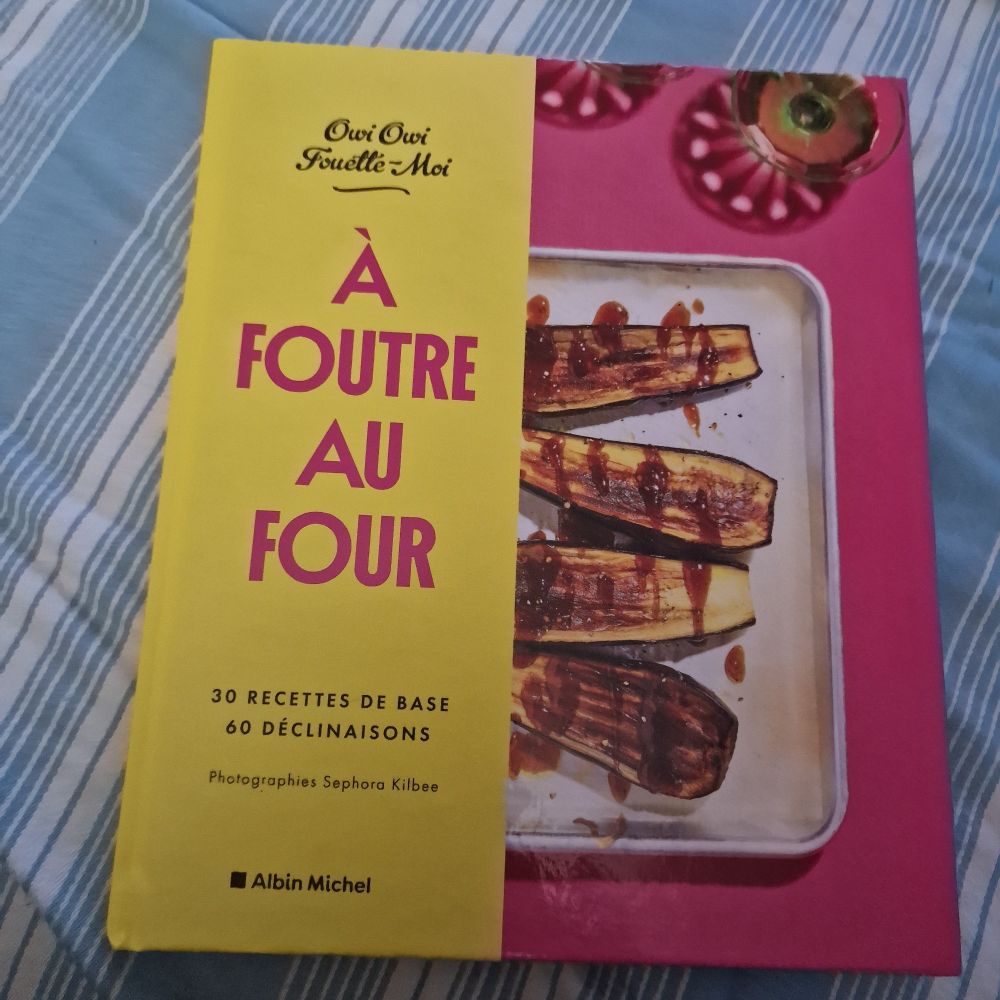 Survie côté gauche du livre de cuisine, sur fond jaune :
Á foutre au four 
OwoIOwi fouette moi
30 recettes de base 60 déclinaisons 
Albins Michel

Sur le côté droit
Un demi plat à gratin blanc avec des 1/2 aubergines rôties
