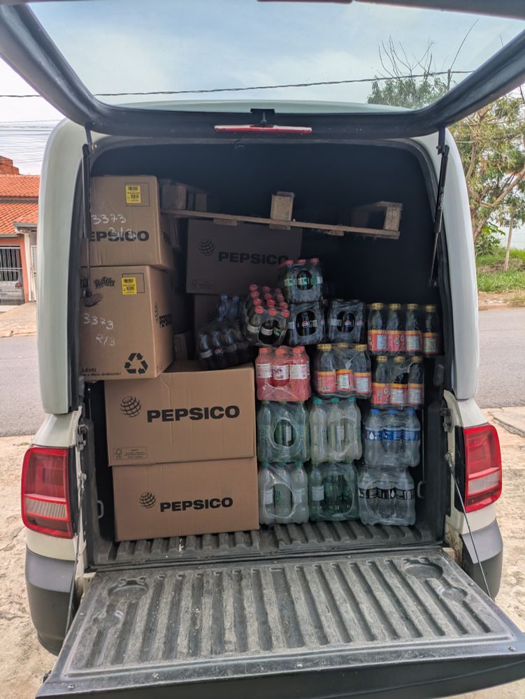 A caçamba de uma Saveiro com capota fechada, cheia de produtos (refrigerantes e caixas da PepsiCo)