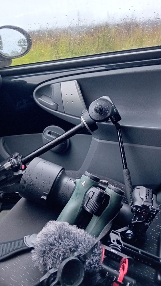 Natte verrekijker en camera op de bijrijdersstoel.