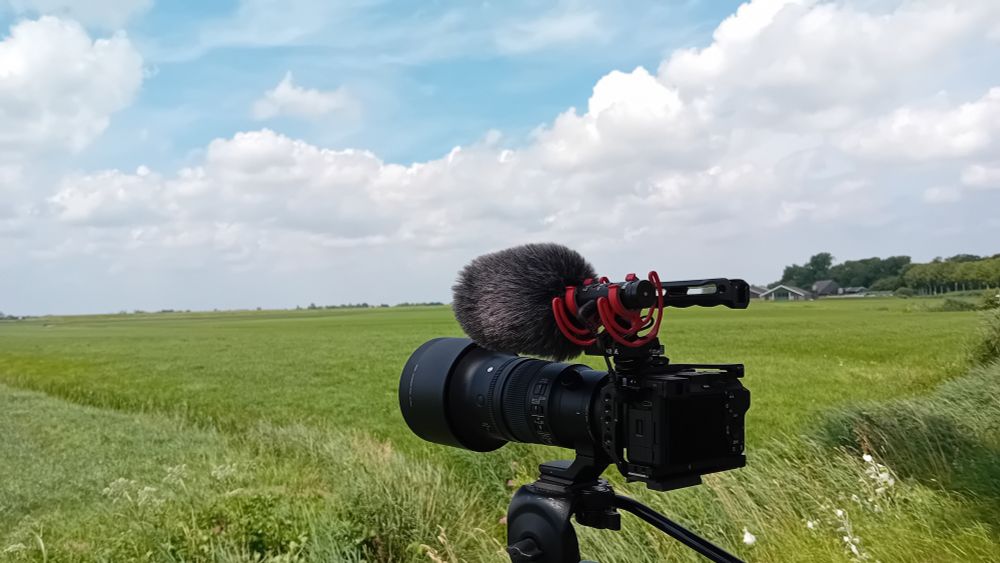 Camera met weilanden op de achtergrond.