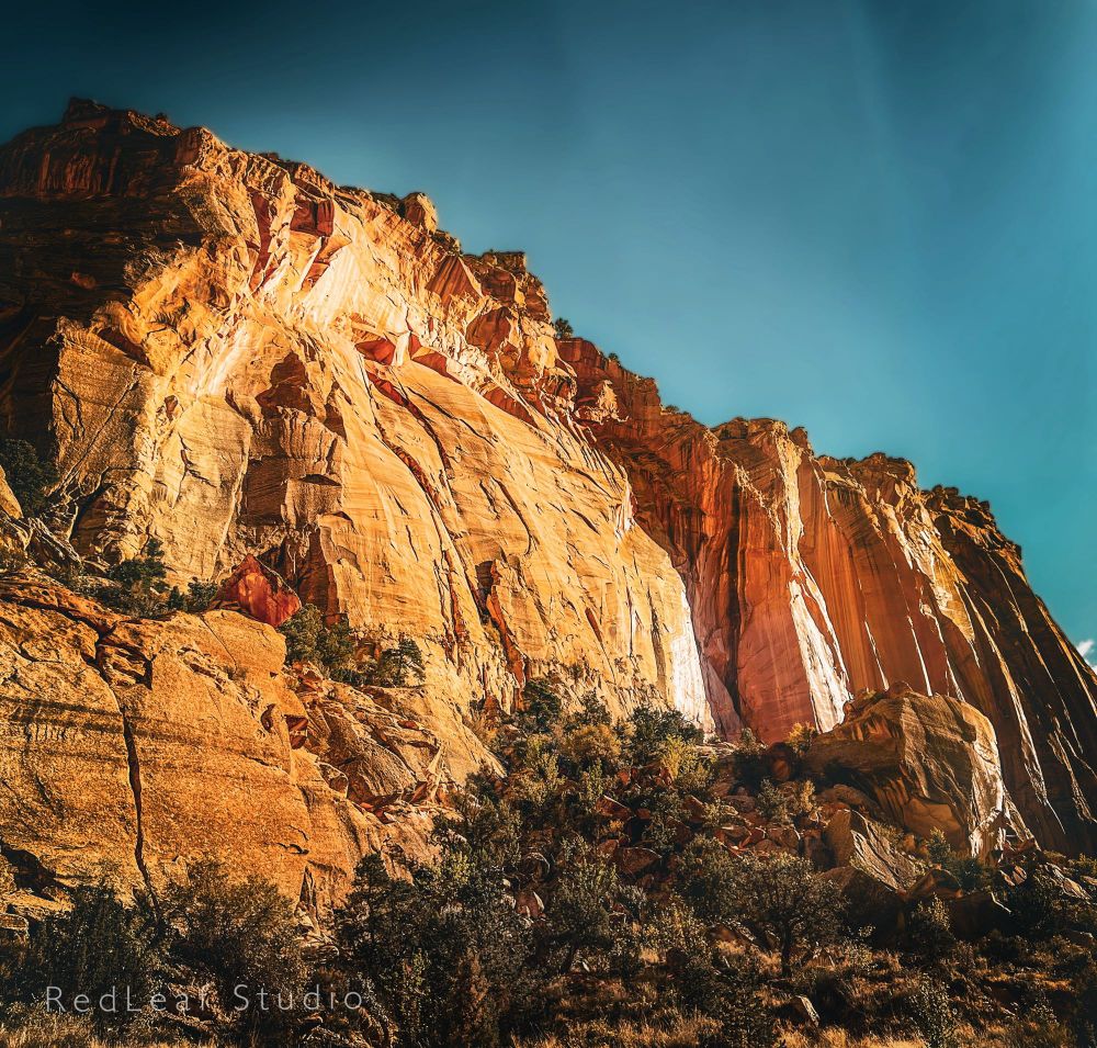 Orange rock formations seem to push up toward the blue sky. 