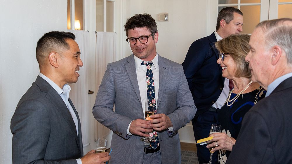Chief resident John Andrews, MD (center) and his parents (right) speak with pediatric neurosurgeon, Kurtis Auguste, MD (left).