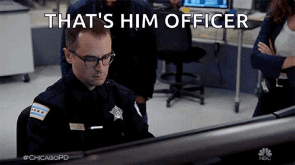 a police officer is sitting in front of a computer with the words that 's him officer above him