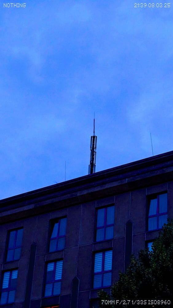 A beaten up LTE tower on top of a care home. It's visibly bent. 