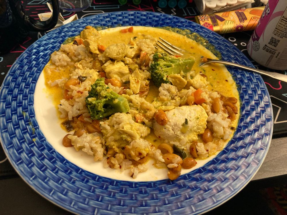 Rin's plate with Thai yellow curry chicken with broccoli, carrots, ginger rice, and chili-lime peanuts.