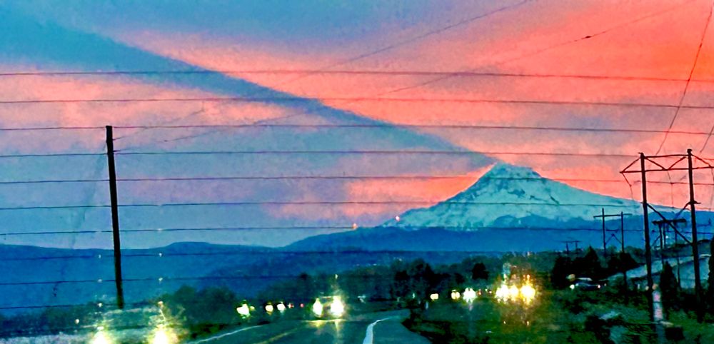 A grainy phone photo, taken out of the rear windshield. Mount Hood, casting a shadow across the sunrise-hues clouds. I really, really wish I’d been able to pull over and take a better picture, but the moment was an amazing one, and this is the best I can do to share it with you.