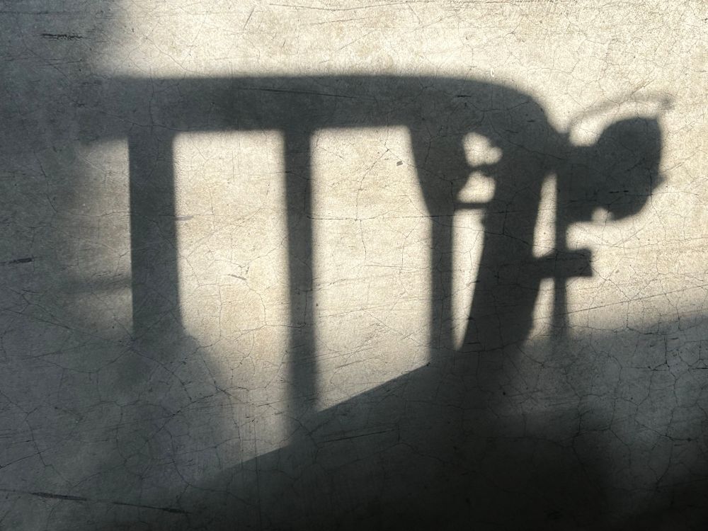 Photo. A skylight throws shadows from a forklift on a concrete warehouse floor.