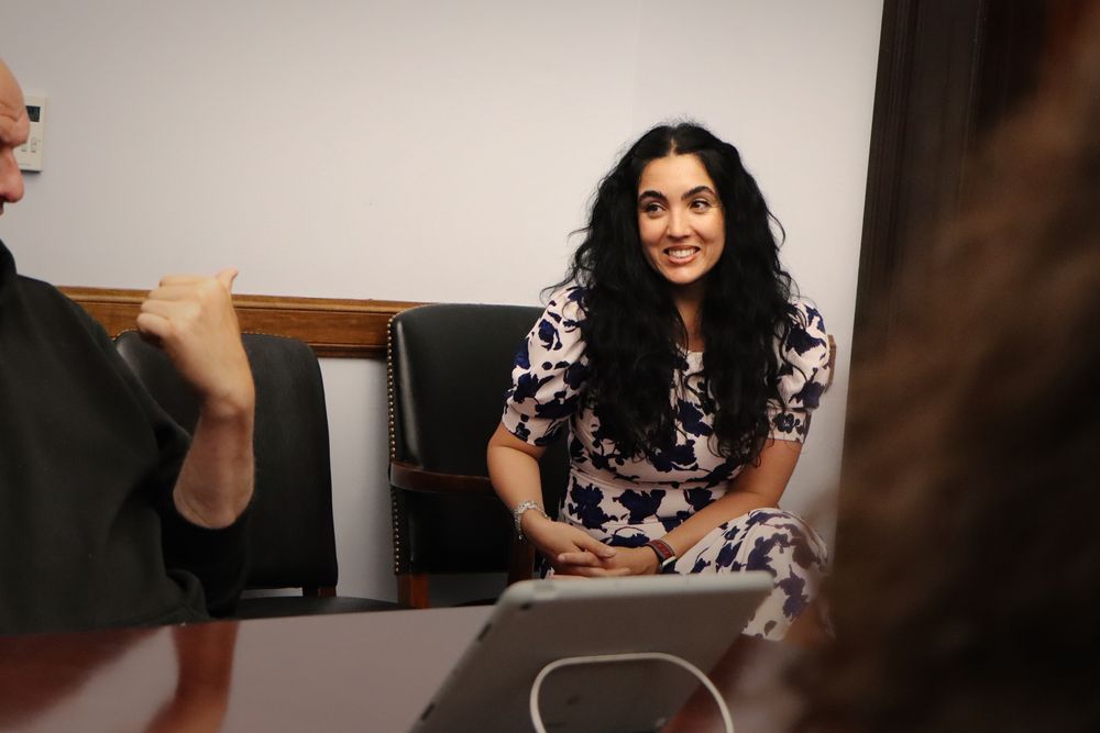 Senator Fetterman pointing to his wife, Gisele, as she smiles during a surprise drop-in with Penn State journalism students.