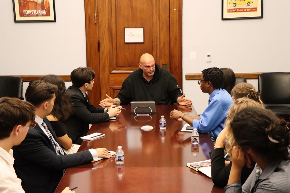 Senator Fetterman sitting at a table and having a conversation with Penn State journalism students in his D.C. office.