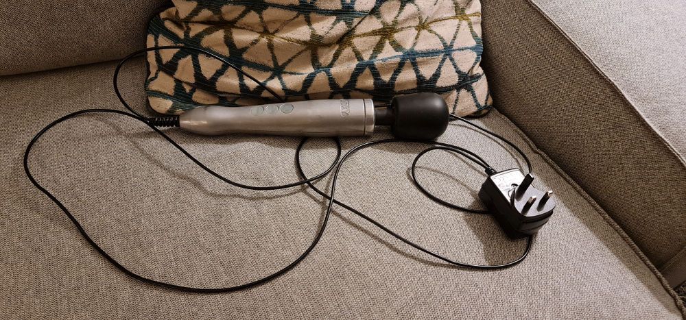 A broken vibrator lies on a couch