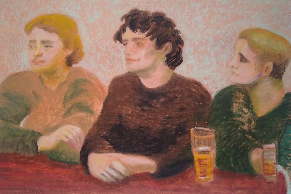 Three people at sat at a bar. The young woman on the left looks upset. The young man in the middle looks oblivious. The young man on the right glances at the other too with surprised concern.