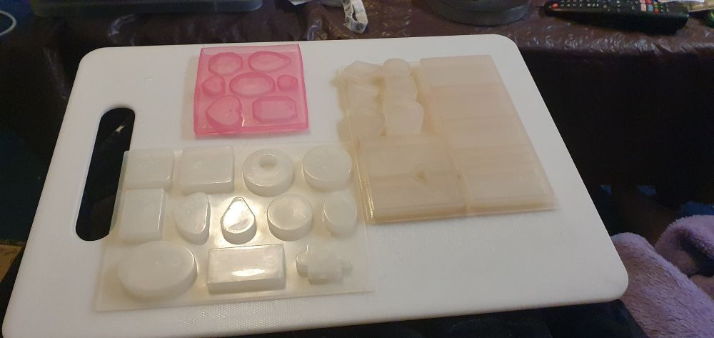 Three resin molds drying on a chopping board.