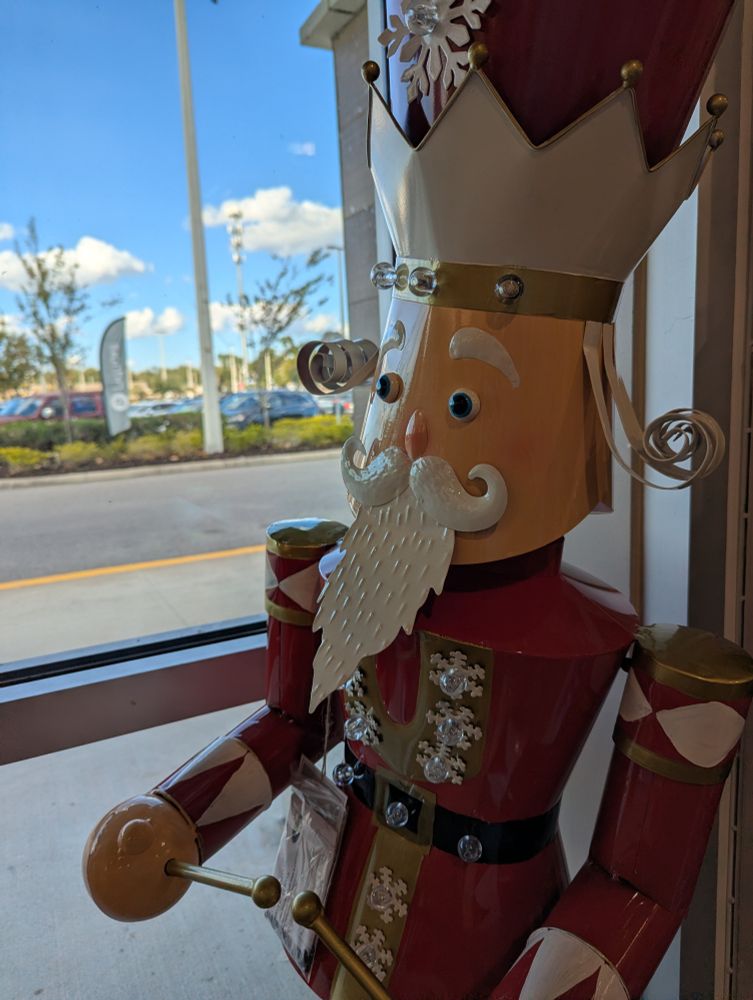 A large aluminum nutcracker-style drummer with a surprised expression 