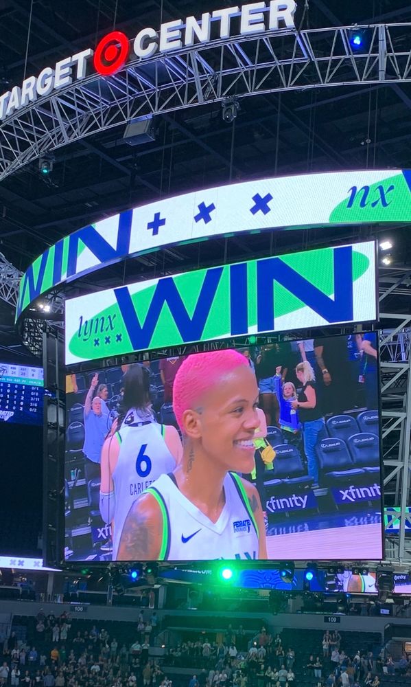 Courtney Williams smiling on the Target Center Jumbotron.
