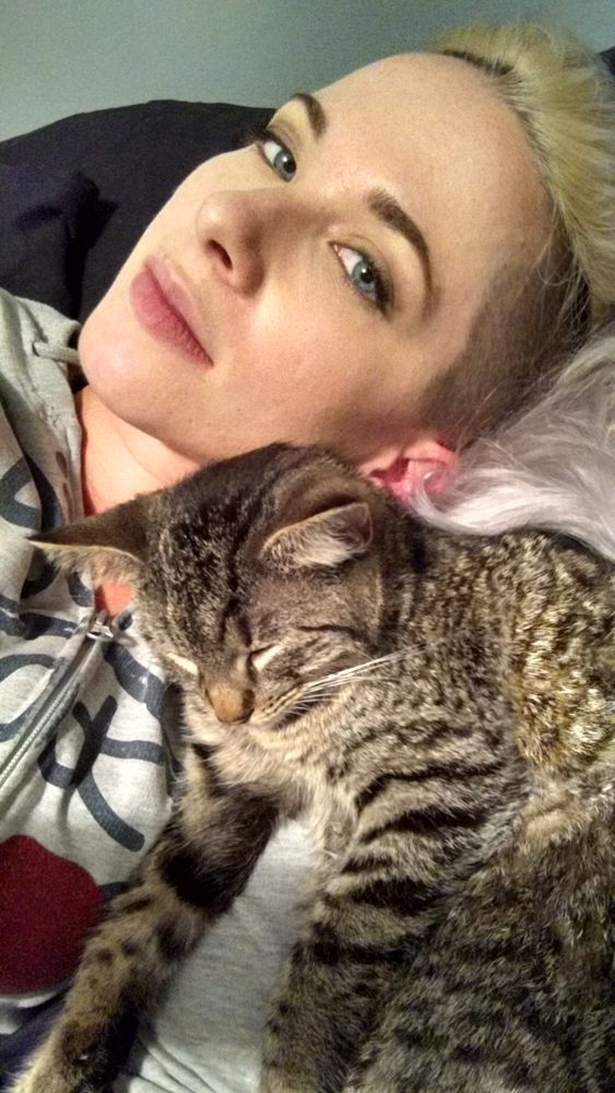 The author, a natural brunette, sporting a white-blond mohawk and cuddling a tabby kitten