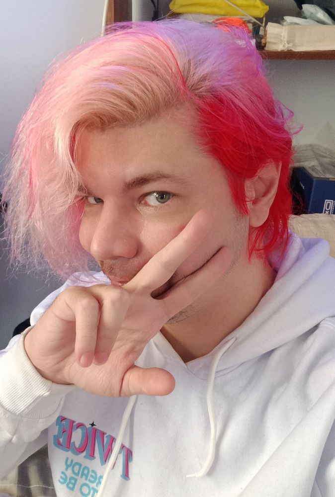 Manchae de moletom branco mostrando o cabelo de cor fantasia dividido entre loiro (no topo) e vermelho (embaixo) 