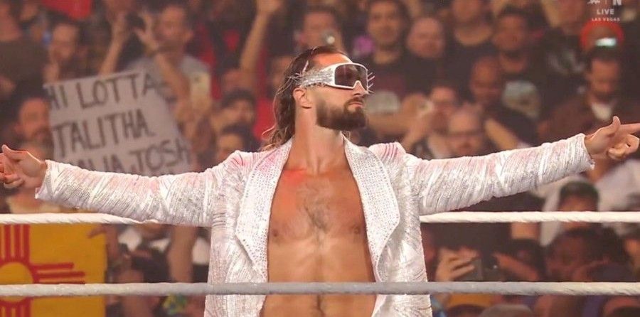 Seth Freaking Rollings de óculos escuros, vestido de branco e de braços abertos