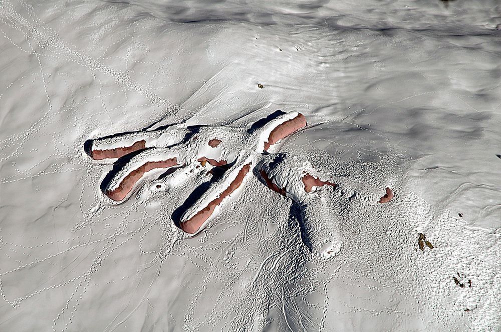 An overhead shot of a giant knitted rabbit covered in snow