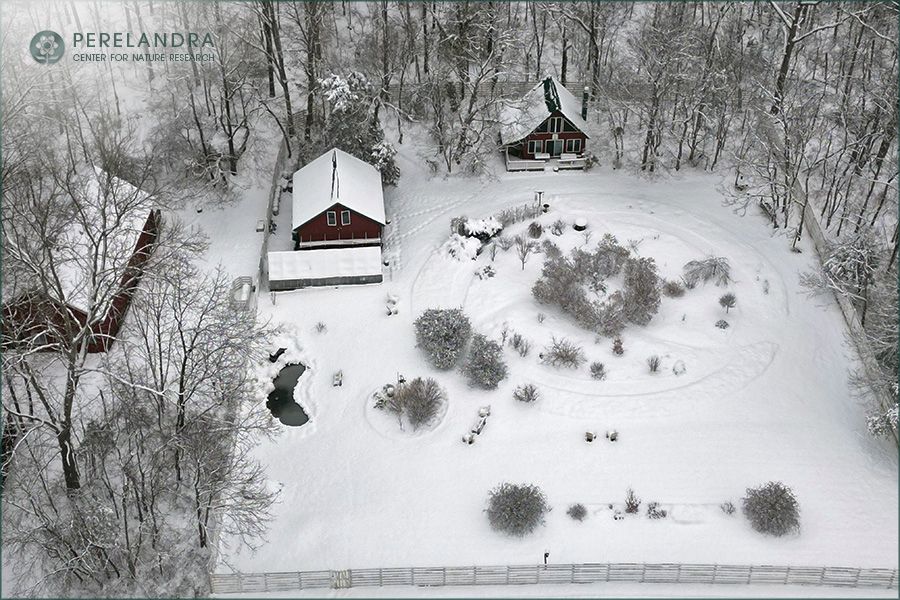 Overhead image of the Perelandra garden, building, grounds and woods edge all covered in a layer of snow.