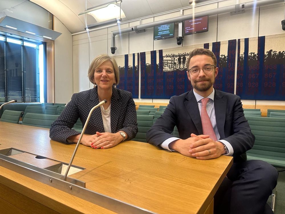 Luke and Lilian sat together at a desk smiling.