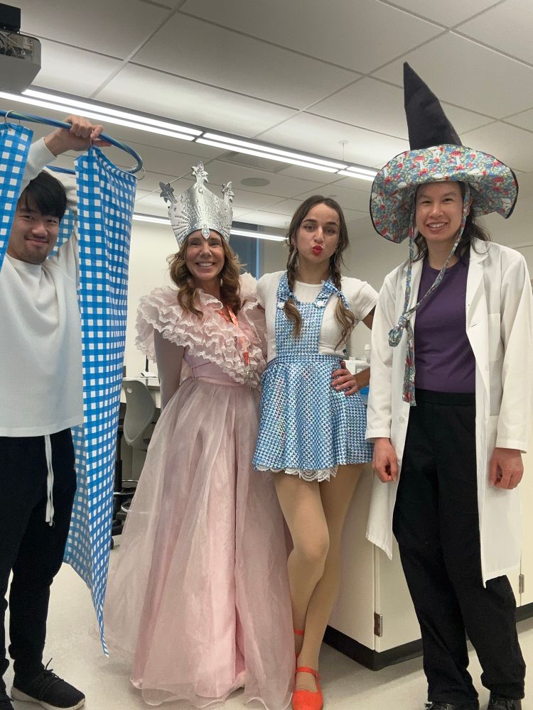 4 people in Wizard of Oz costumes in a lab