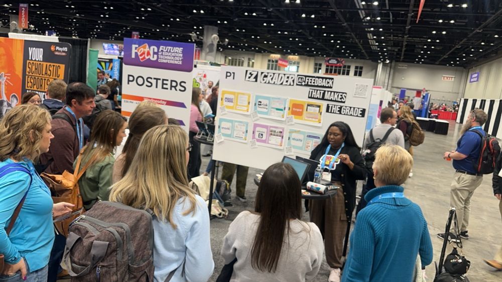 Wide shot of poster session board, attendees, and presenter at FETC. 