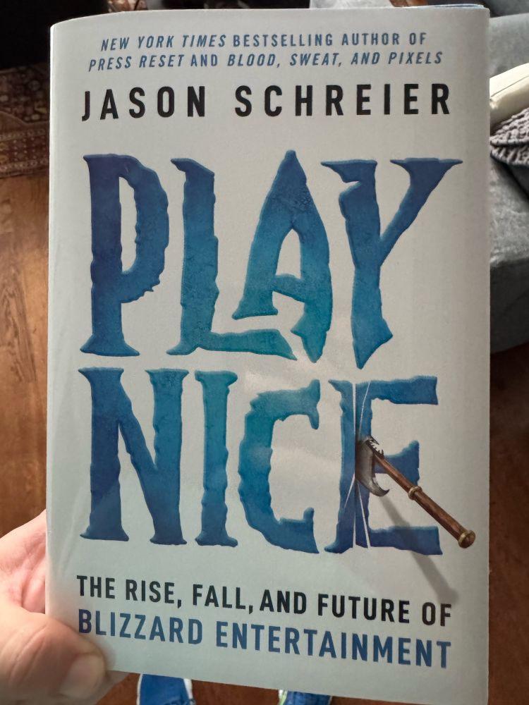 Poster is holding a hardcover copy of Play Nice: The Rise, Fall, and Future of Blizzard Entertainment by Jason Schreier