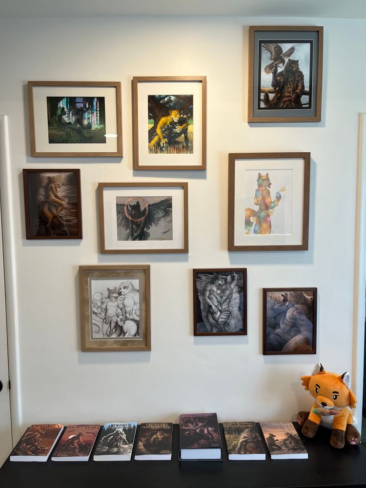 A set of Red Lantern books on a dresser, with a plush fox next to them, and framed art above them