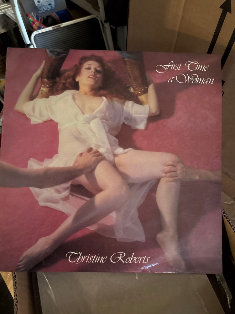 Cover for 1978 album by Australian folk singer Christine Roberts, showing her spread-eagled on the floor, with one man standing over her head and two more sets of male hands grabbing her thighs and knees. It’s … really bad