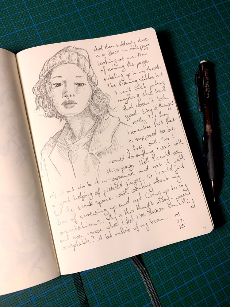 Photo of a page in my sketchbook. It shows a portrait drawing of a female looking face wearing a beanie. The rest of the page has small hand written text.
