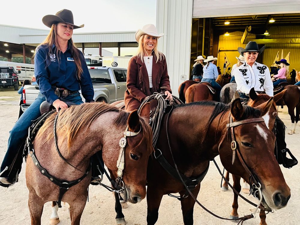Mayor Deegan, and two other people on top of horses, smiling at the camera
