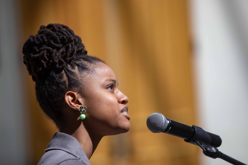 A young woman speaks into a microphone