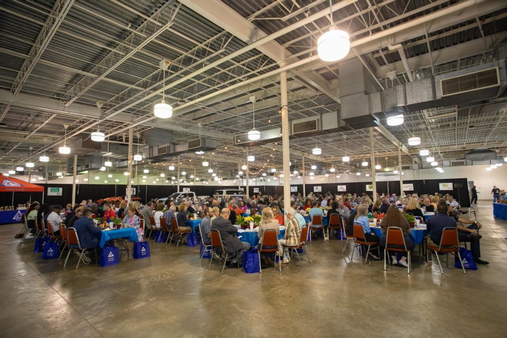 a large room with people seated at tables for the farm city luncheon