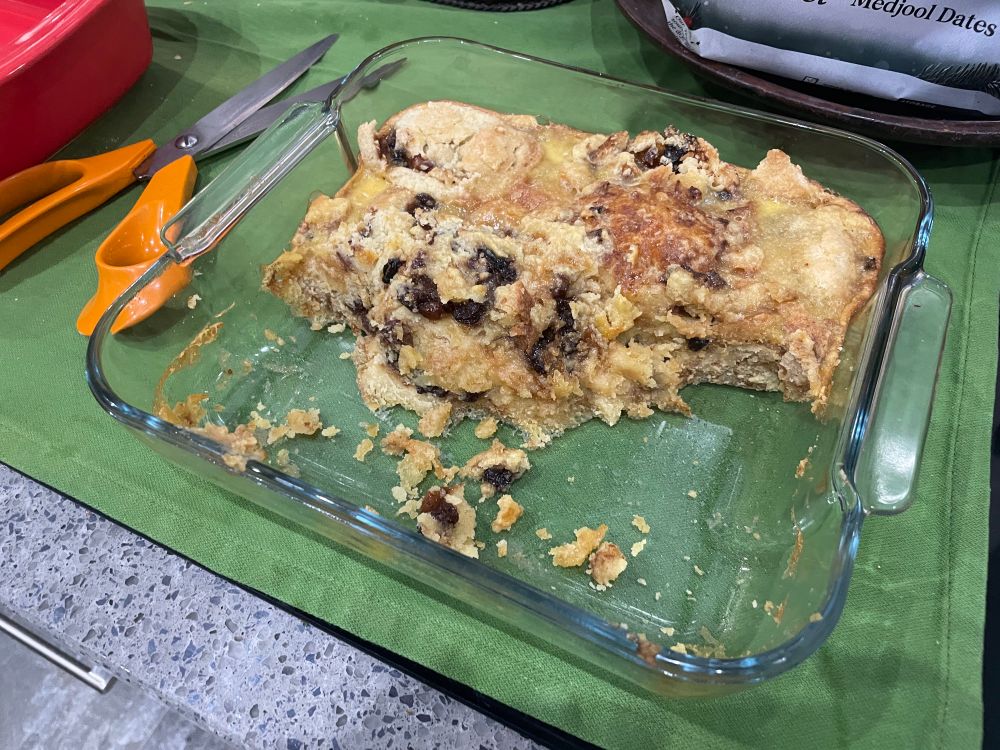 A baking dish containing a half-eaten mince pie pudding