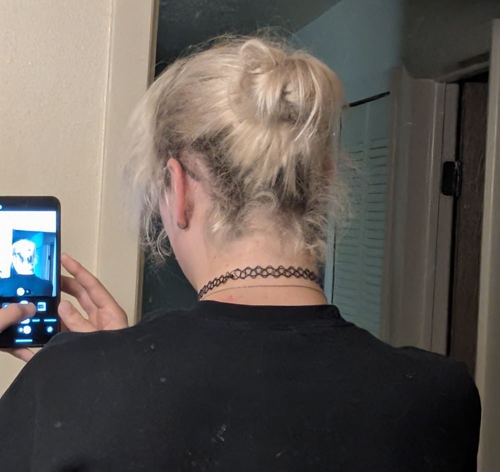 the back of my head (my hair is tied in a messy bun and I'm wearing a black sweater)